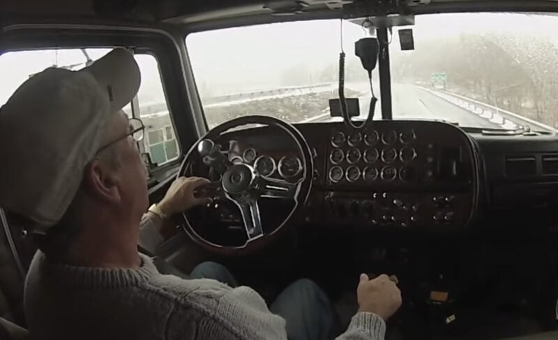 Experienced truck driver shifting gears in a manual transmission truck.