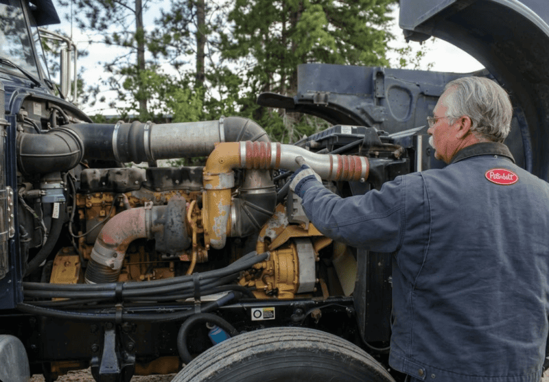 truck driver working on a cat diesel engine